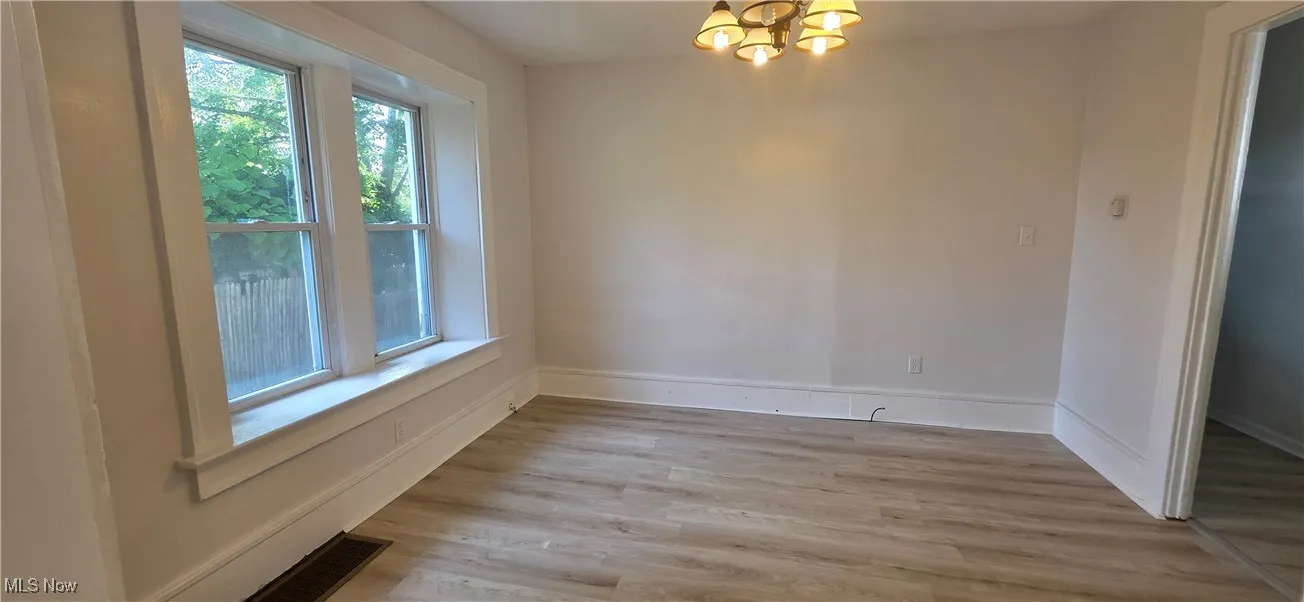 dining room featuring plenty of natural light, a chandelier, light lvt finished floors