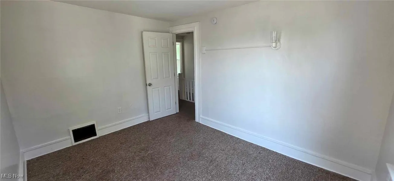 bedroom featuring dark carpet and baseboards