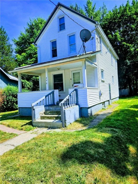 View of front of property featuring covered porch and a front lawn