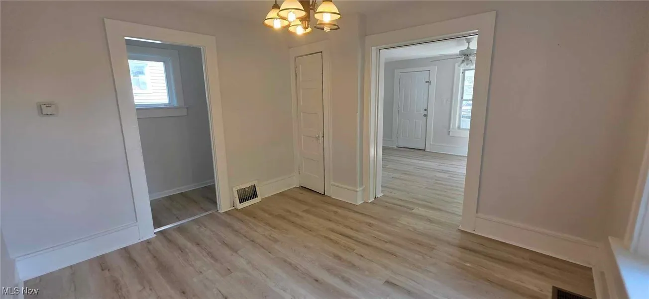 dining room featuring plenty of natural light, a chandelier, light lvt finished floors