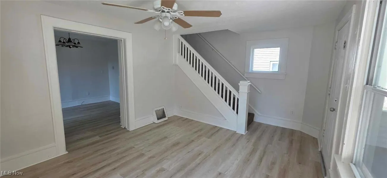 Living room featuring plenty of natural light, light wood-type flooring, and ceiling fan