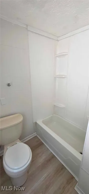 Bathroom featuring lvt floors, a textured ceiling, and shower / tub combination