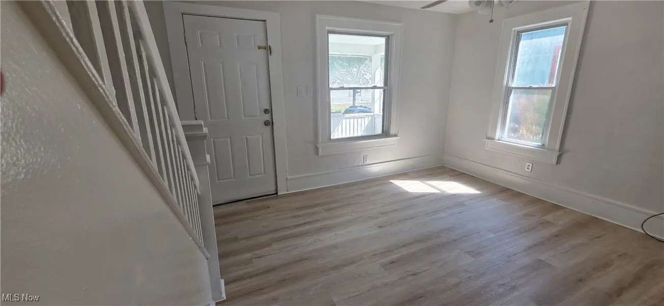 Living room featuring plenty of natural light, light lvt flooring, and ceiling fan