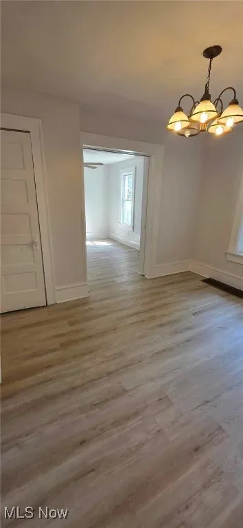 dining room featuring plenty of natural light, a chandelier, light lvt finished floors