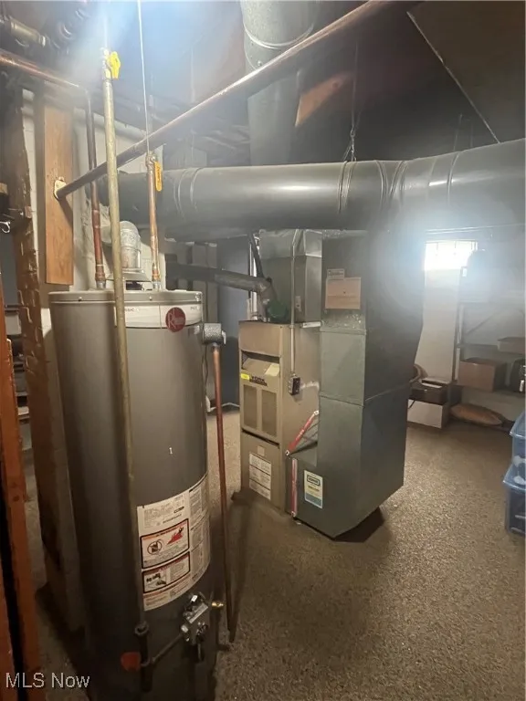 Utility room featuring water heater and heating unit