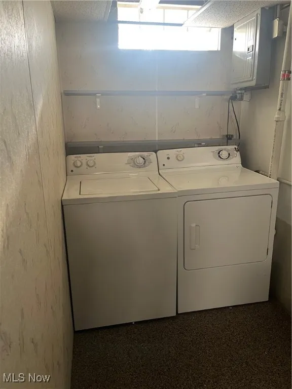Laundry room featuring independent washer and dryer and electric panel