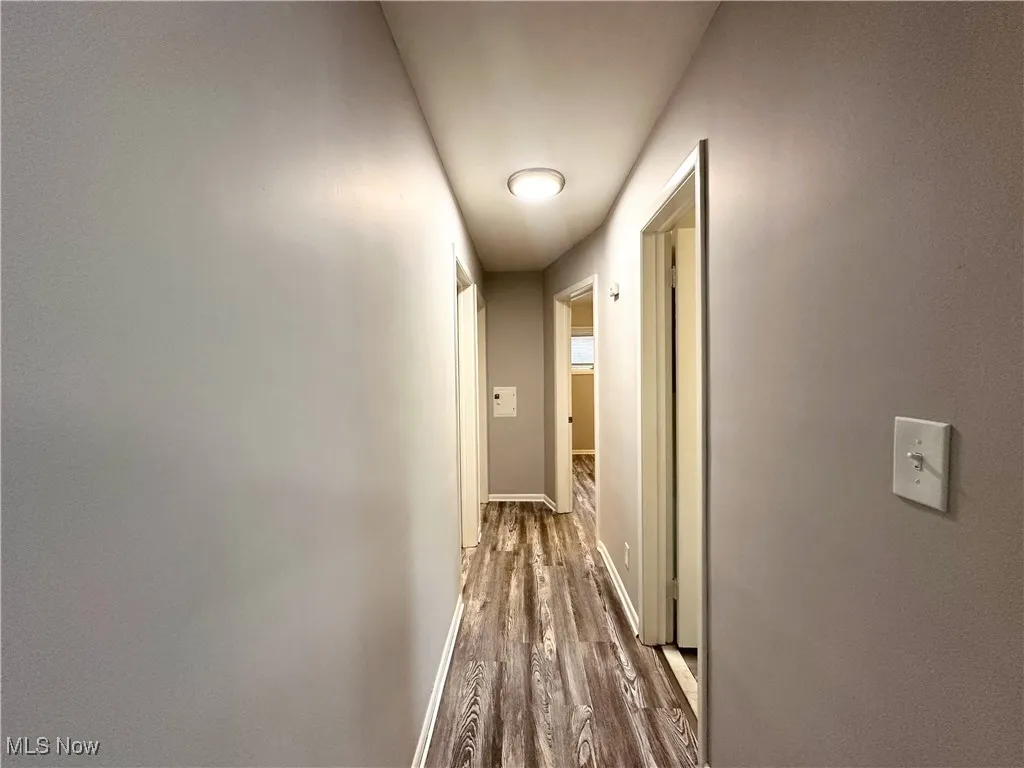 Hallway featuring wood finished floors and baseboards