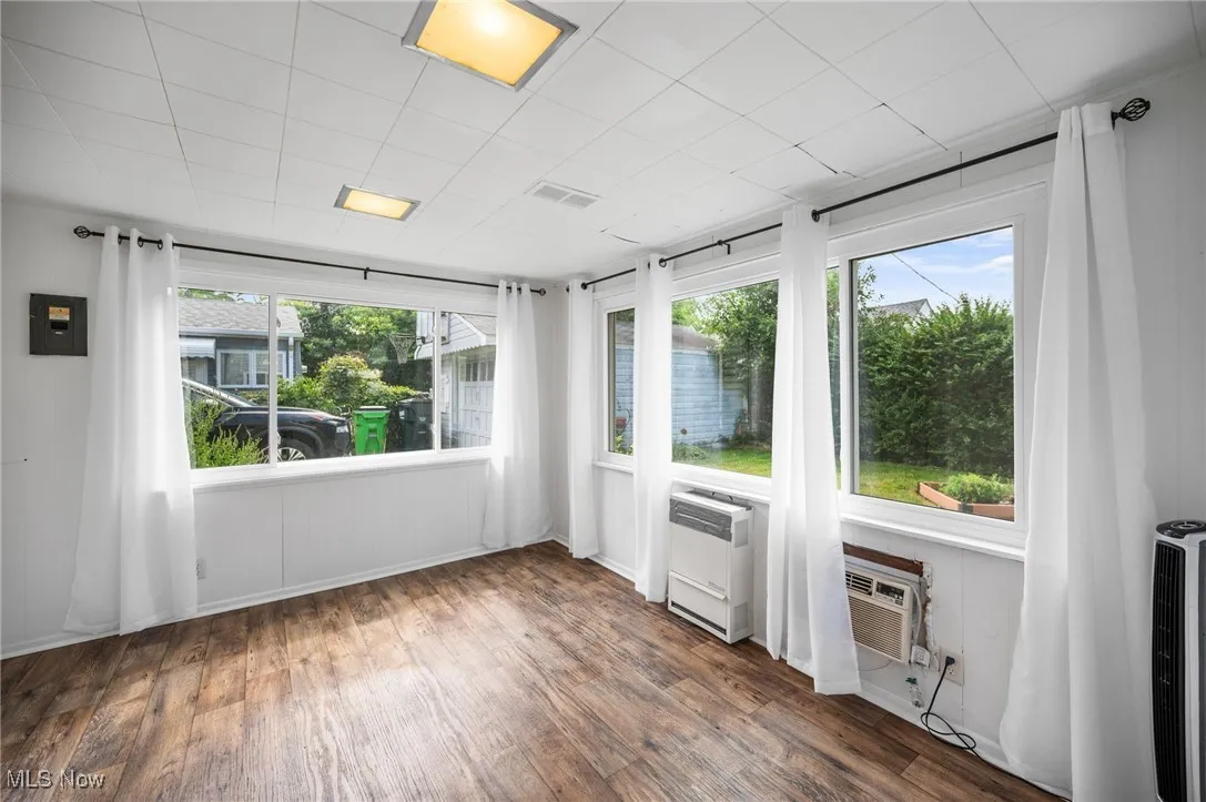 Sun room featuring wood style floors and heating unit