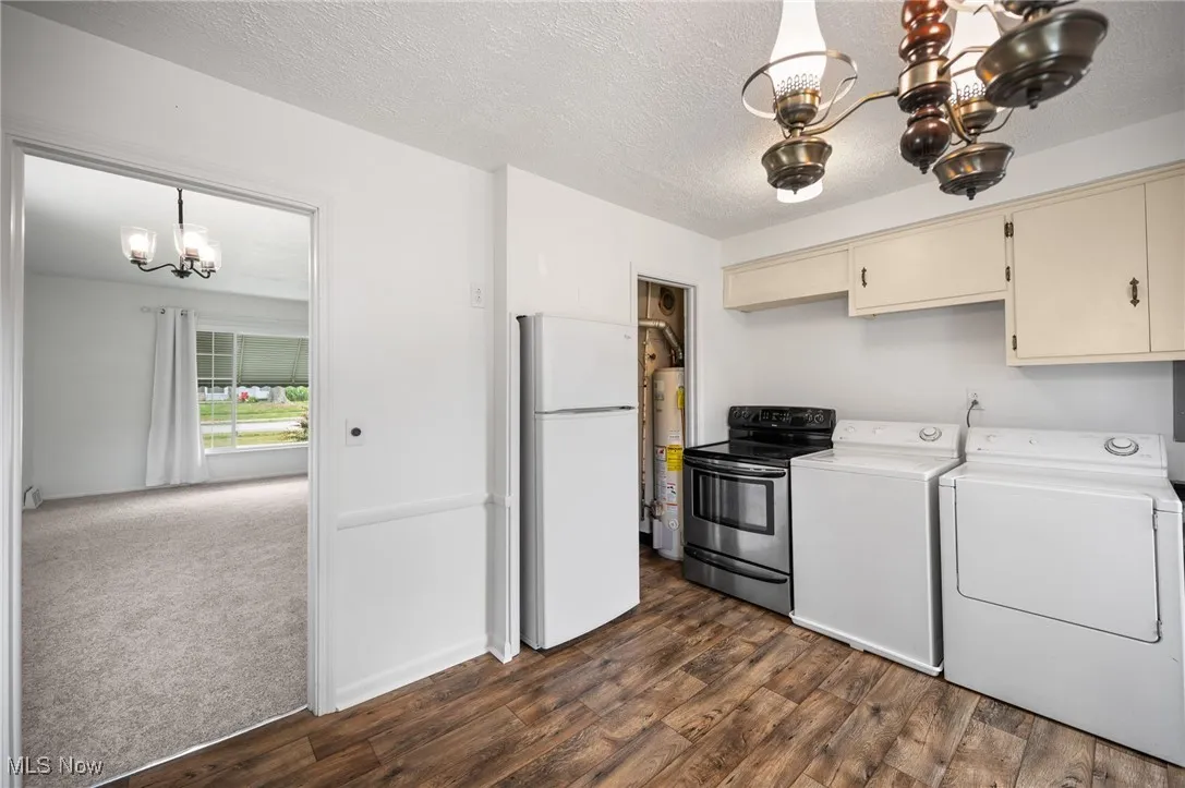 Kitchen featuring a chandelier, wood finished floors, washing machine and dryer, and a textured ceiling