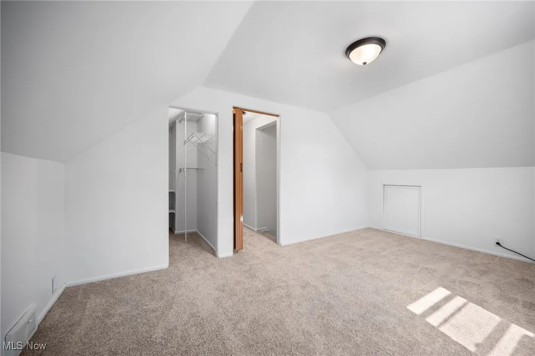 Bedroom featuring carpet and vaulted ceiling