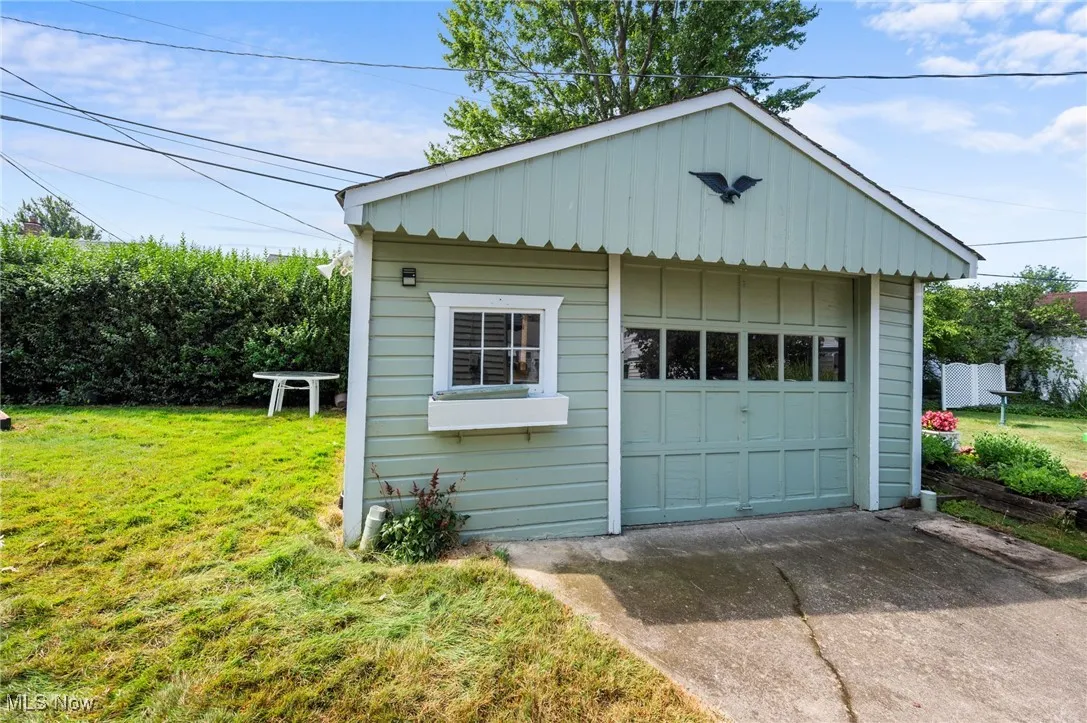 Detached garage featuring concrete driveway