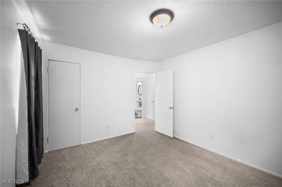 Unfurnished bedroom featuring carpet floors and a textured ceiling