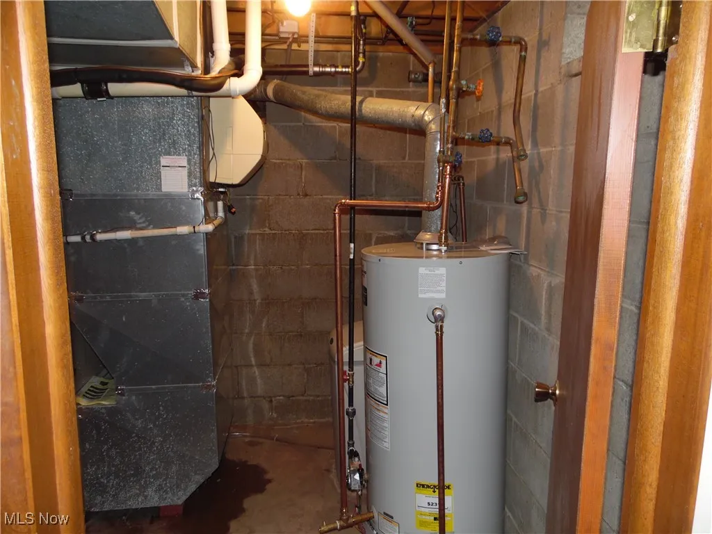 Utility room featuring gas water heater and heating unit