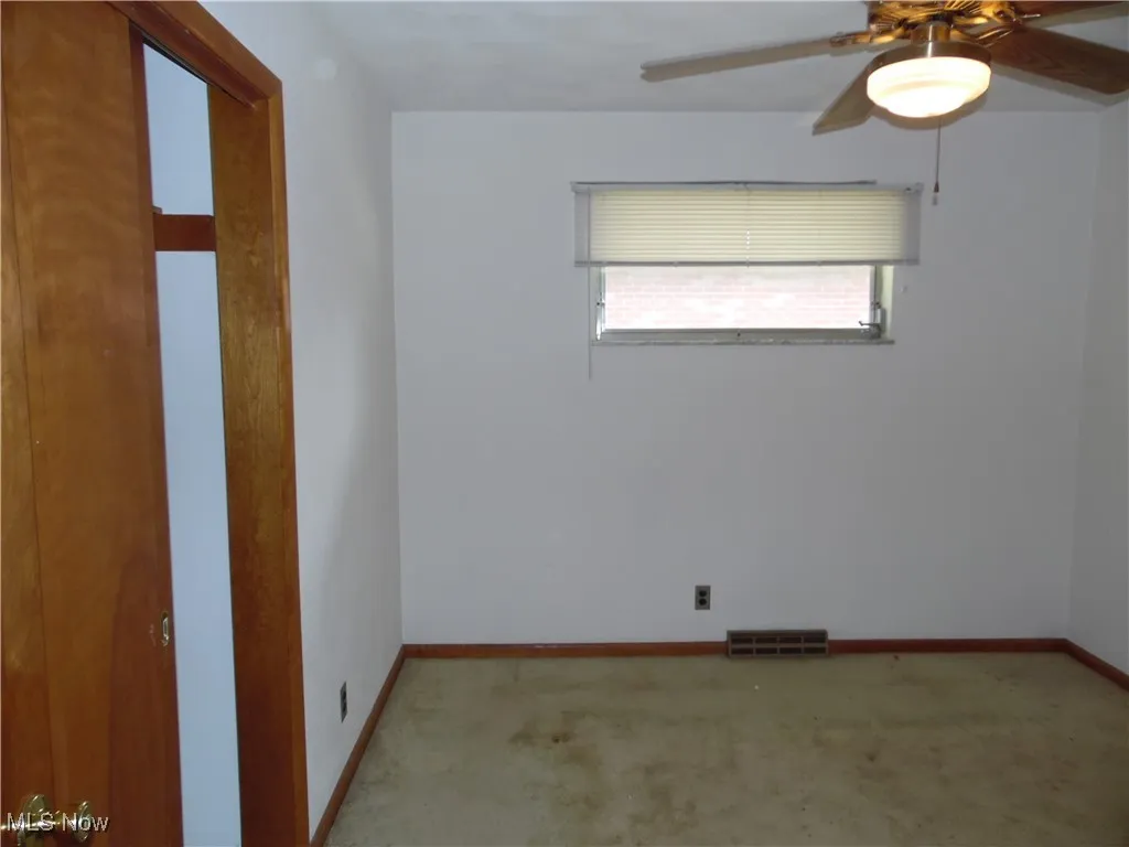 Empty room with ceiling fan and carpet
