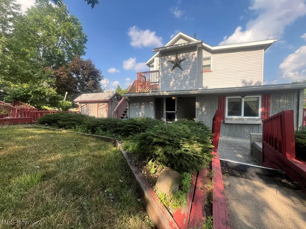 Back of property with stairs and a deck
