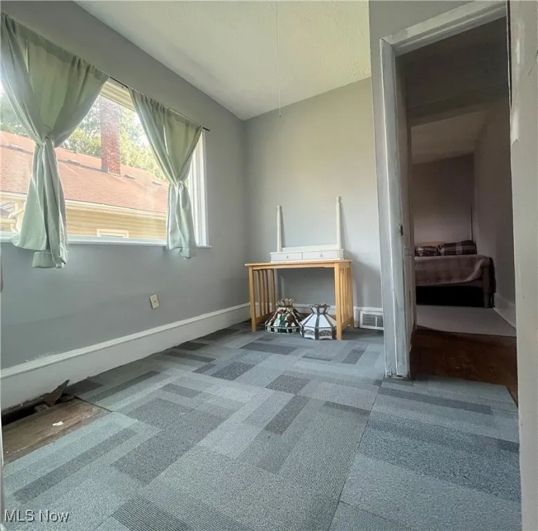 Carpeted home office featuring plenty of natural light