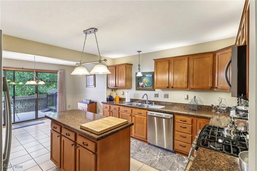 Eat-in kitchen featuring sink, appliances, center island, special lighting and ceramic flooring