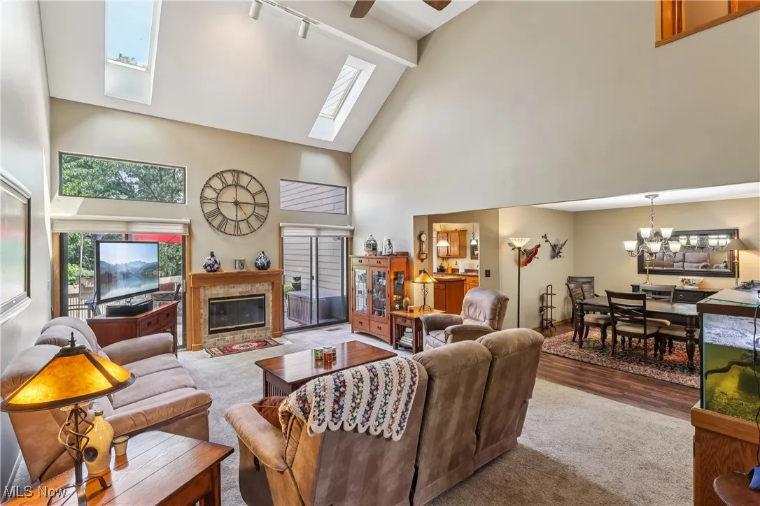 Great room with fireplace, vaulted ceiling, sliding door to back deck and a view of the dining room