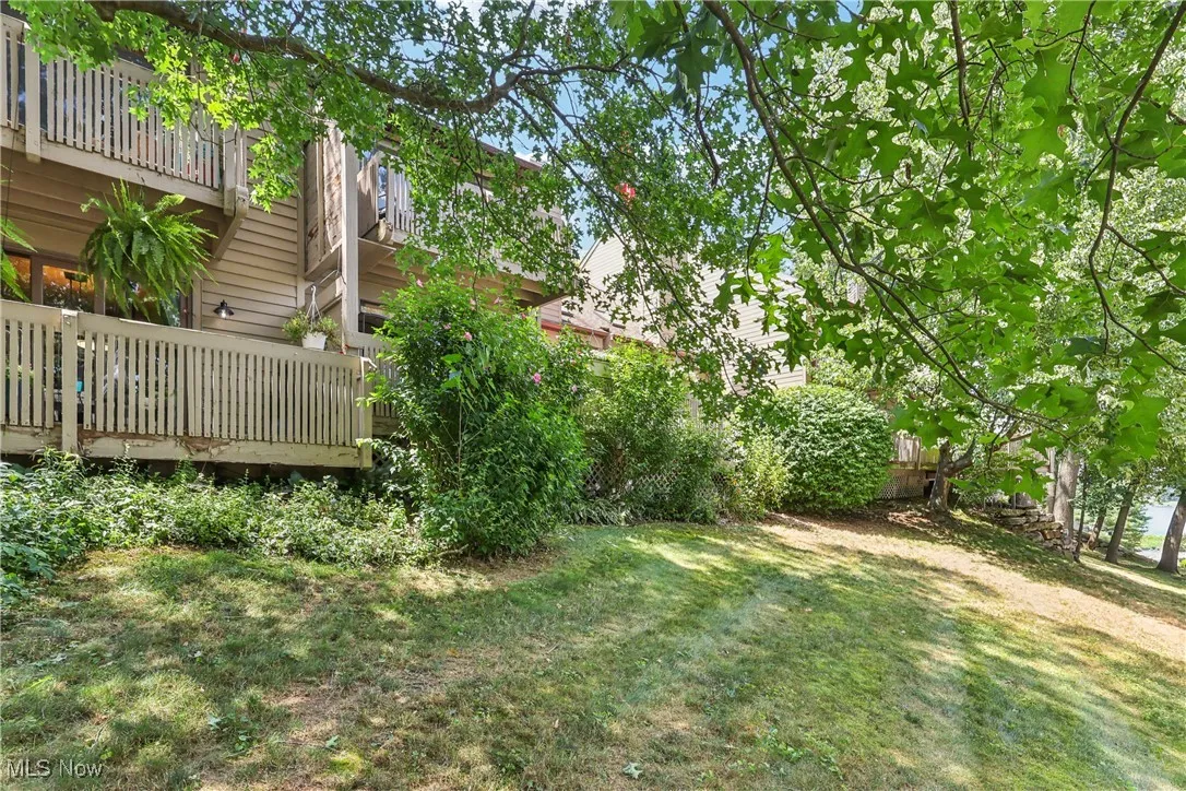 View of grassy yard with a wooden deck