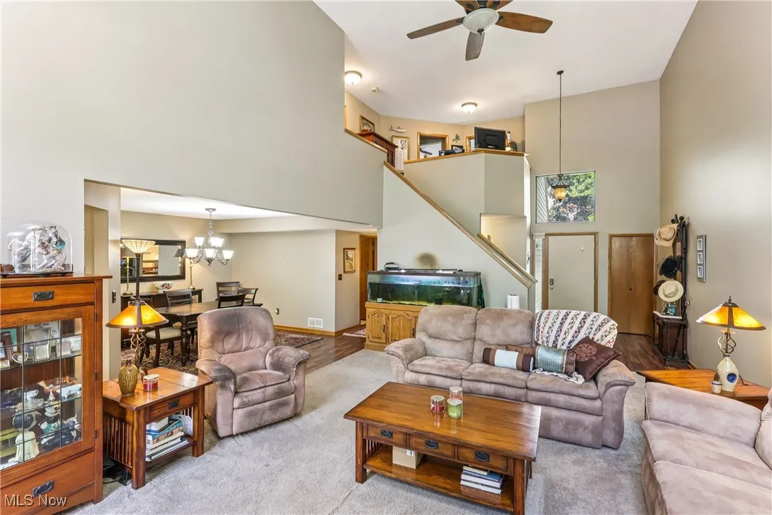 Great room featuring a ceiling fan / light, vaulted ceiling, loft and carpet flooring