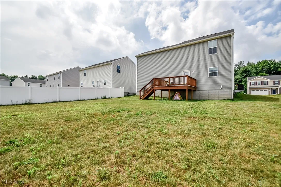 Rear view of property with a wooden deck and stairway