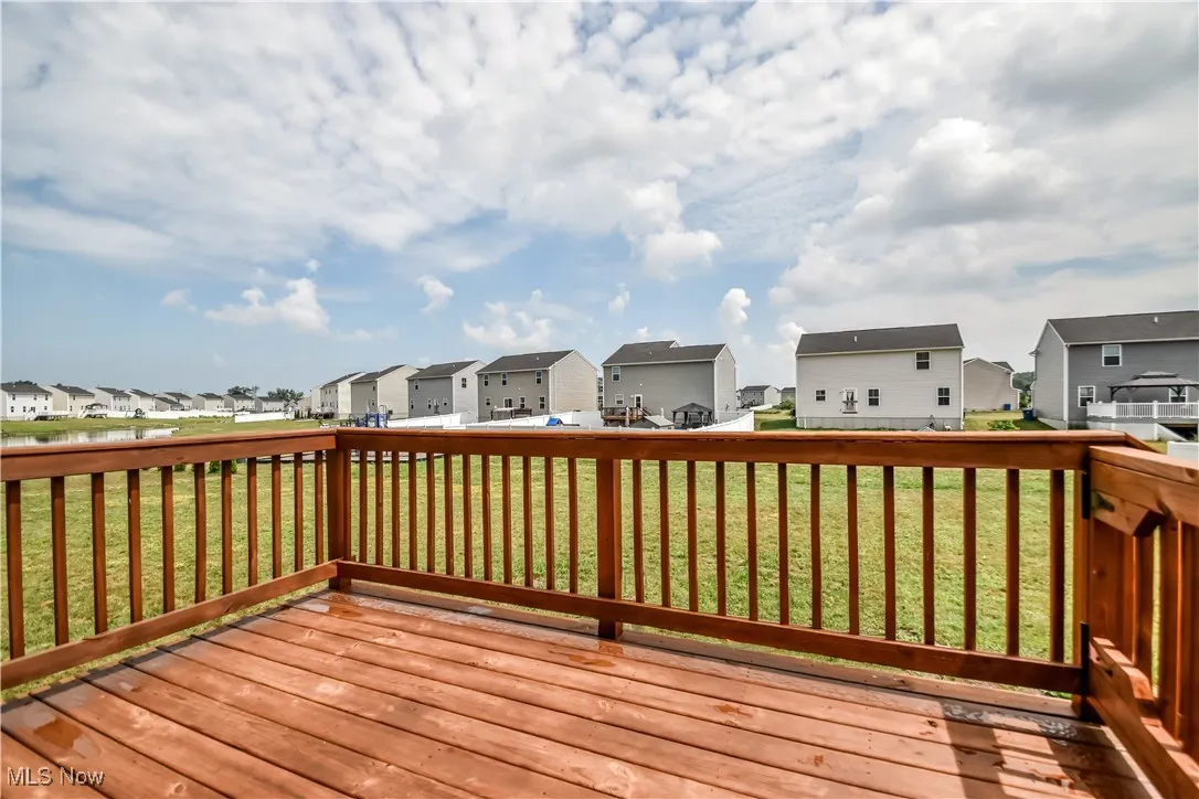 Wooden deck with a residential view and a yard