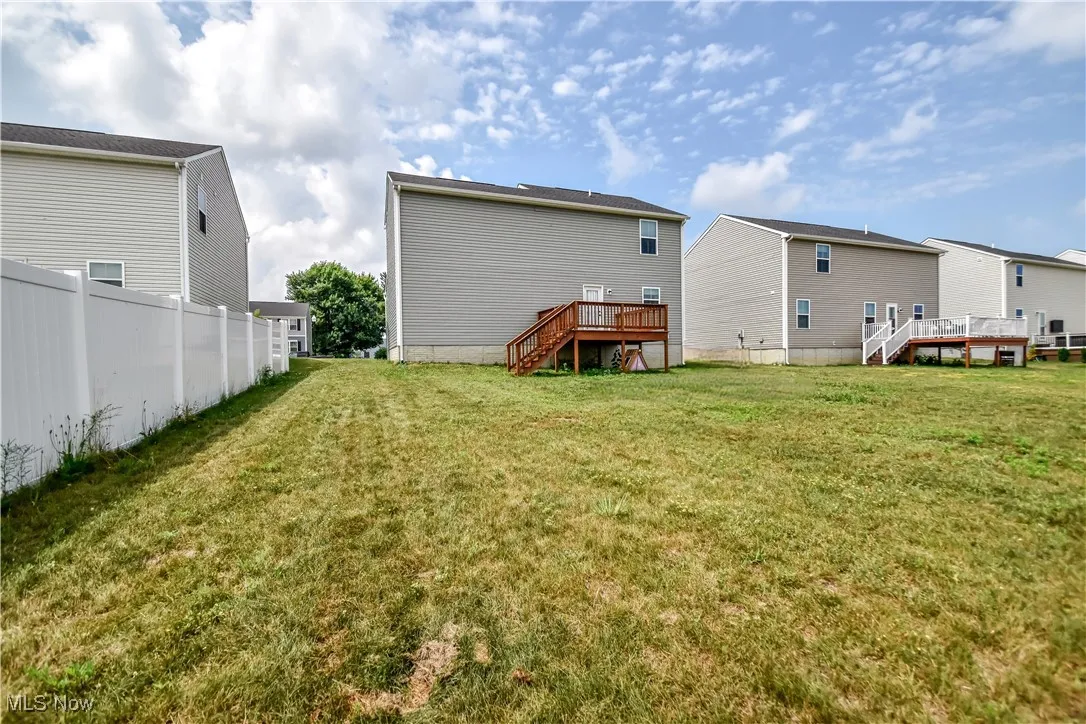 Back of property featuring stairs and a wooden deck