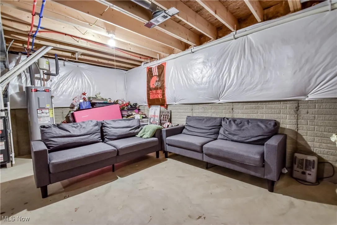 Unfinished below grade area featuring water heater
