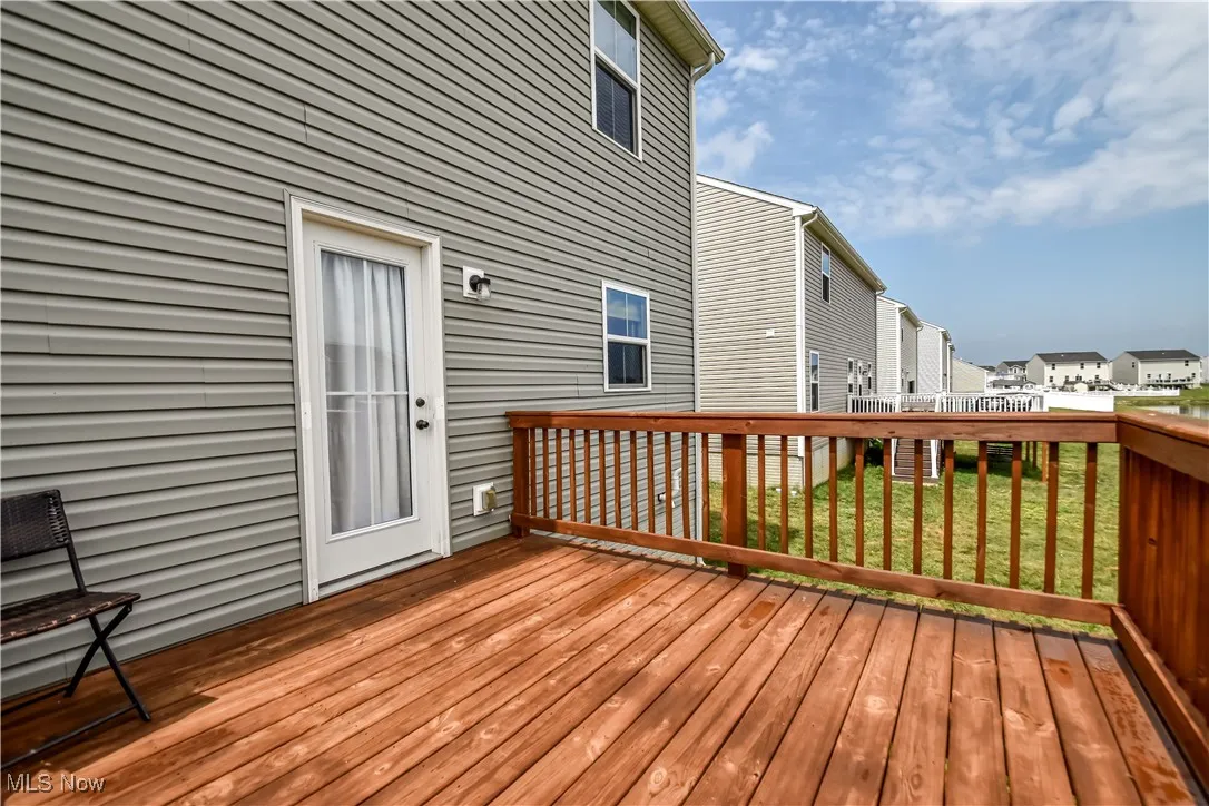 Wooden deck with a residential view and a lawn
