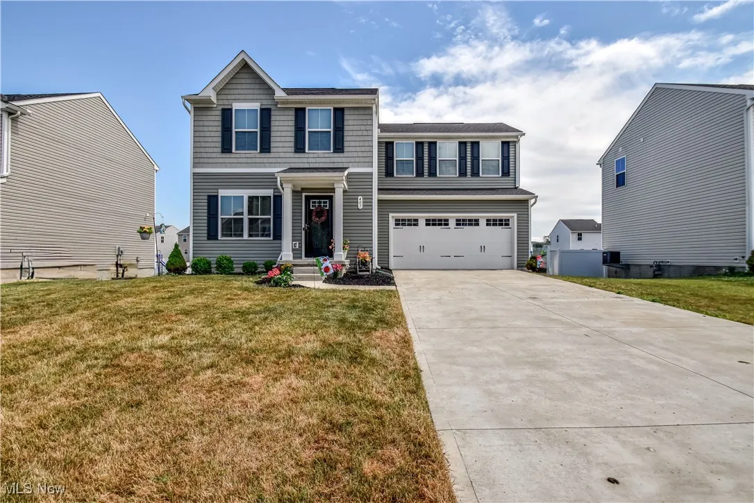 View of front facade with an attached garage, driveway, and a front yard