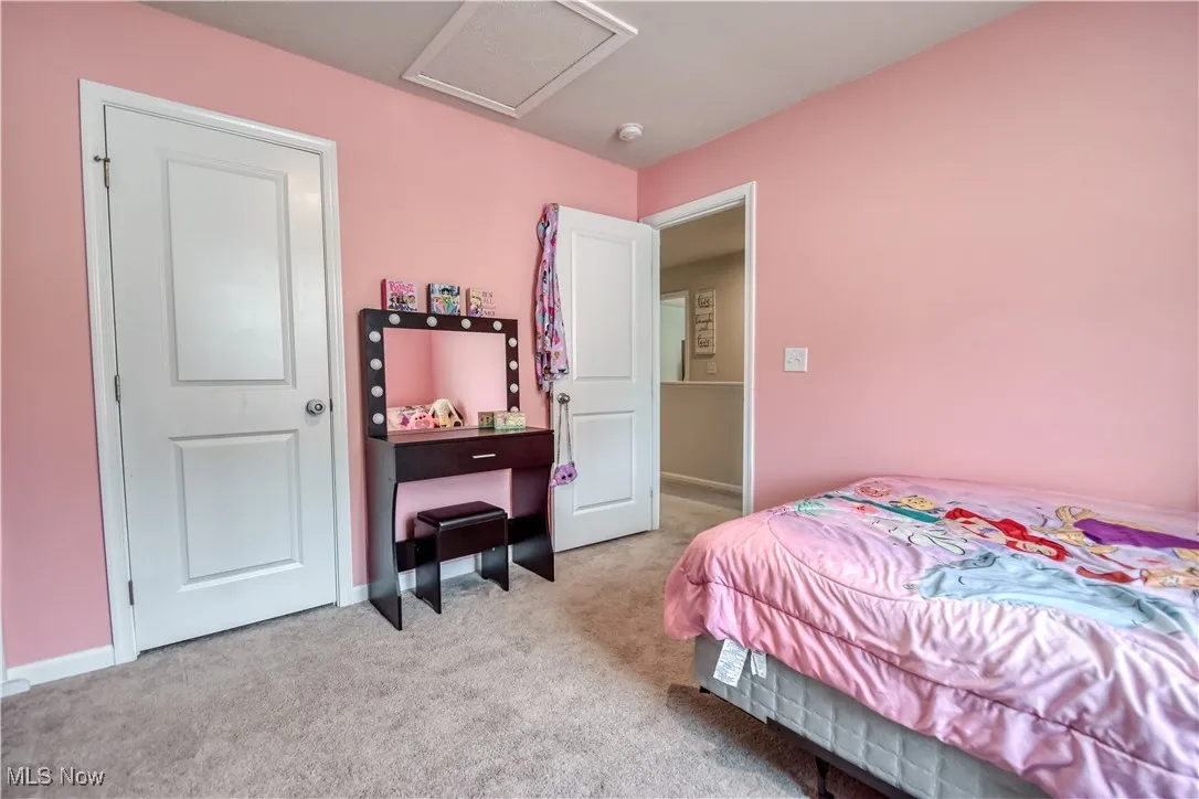 Bedroom with light carpet and attic access