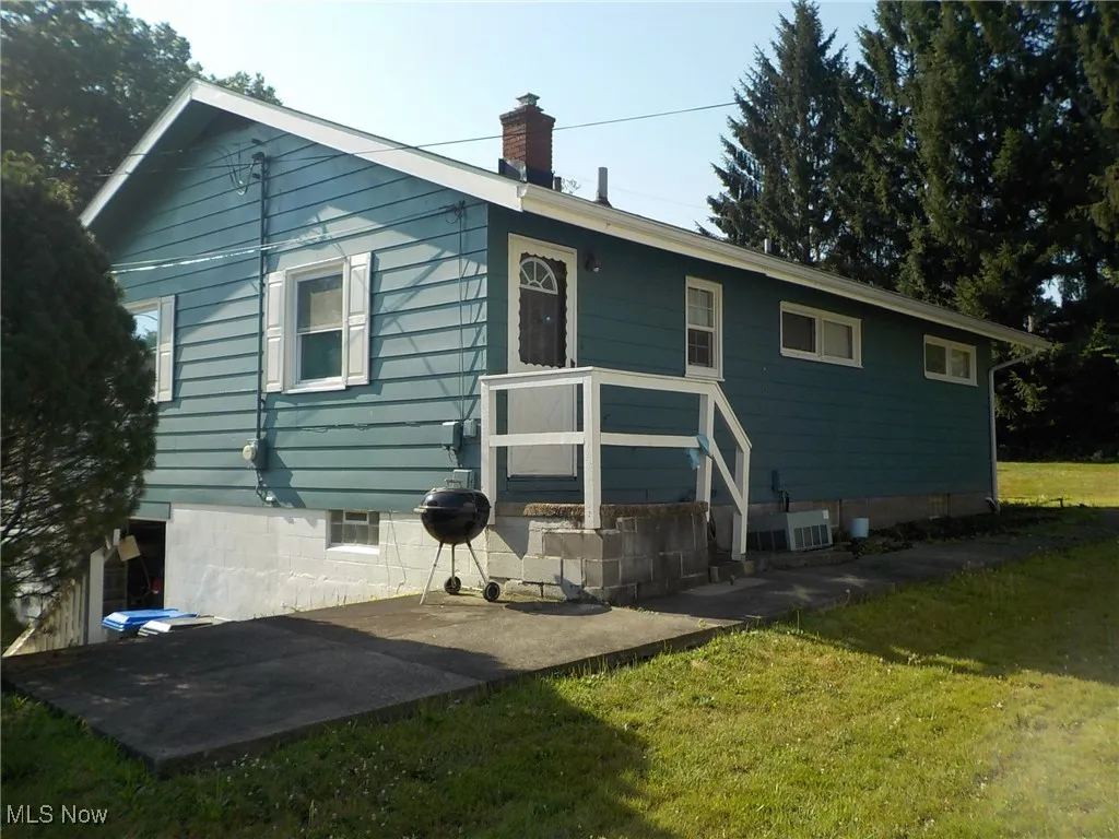 Rear view of house with a lawn and a chimney