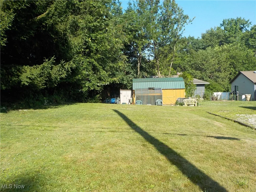 View of grassy yard featuring an outdoor structure and exterior structure
