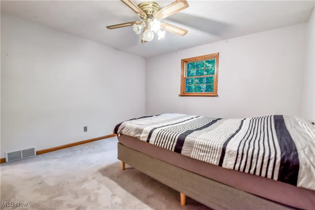 Carpeted bedroom with baseboards and ceiling fan