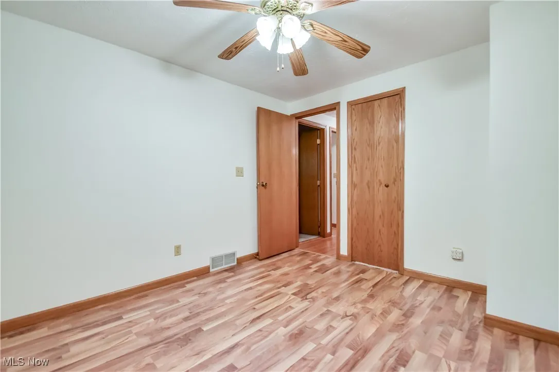 Empty room featuring light wood finished floors and ceiling fan
