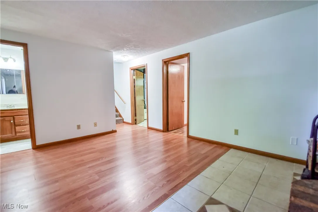 Spare room with stairs and light wood-style flooring