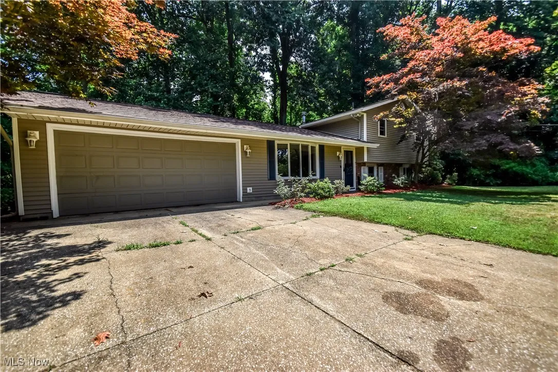 Split level home featuring a front yard and concrete driveway