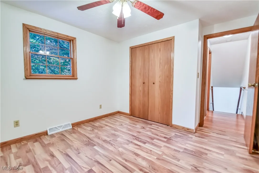 Unfurnished bedroom featuring light wood-type flooring, a closet, and a ceiling fan