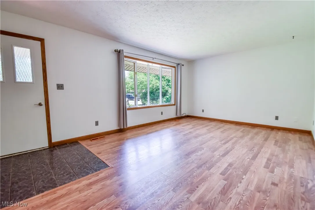 Unfurnished room with light wood-style flooring and a textured ceiling