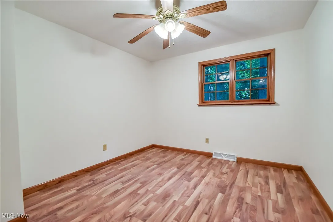 Spare room with light wood-type flooring and a ceiling fan