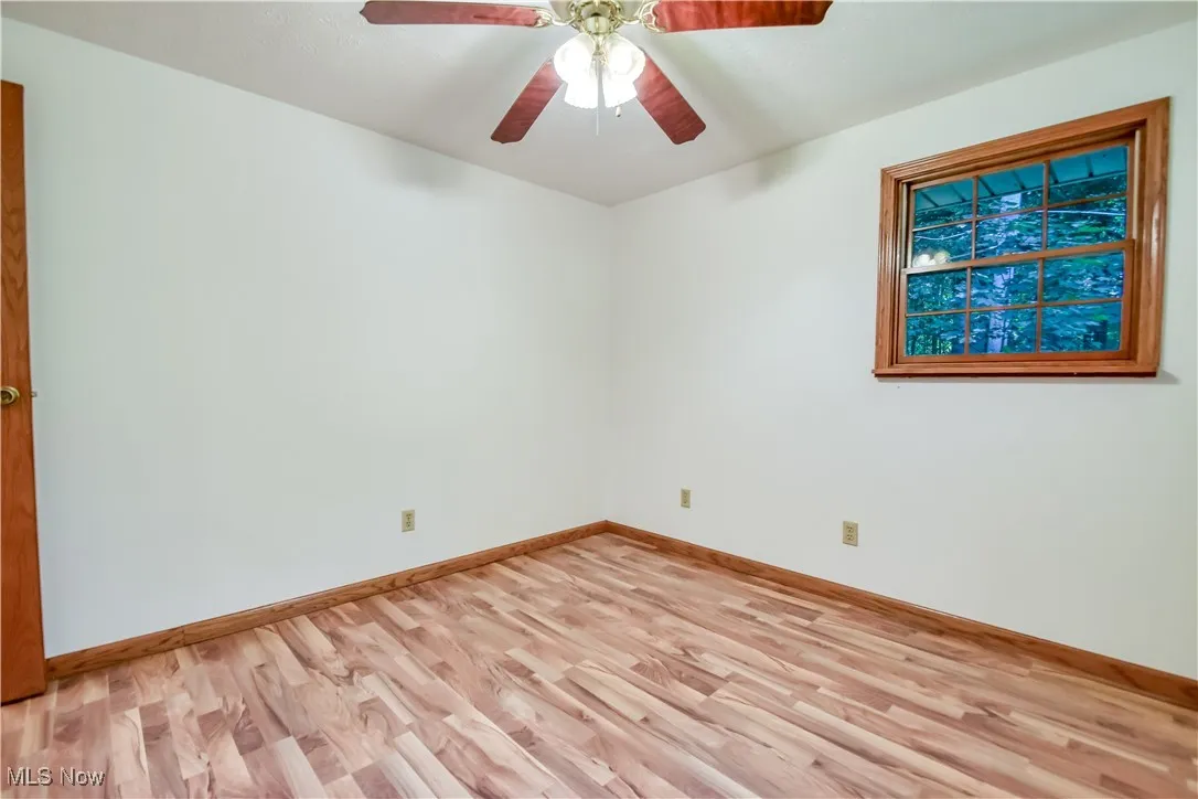 Empty room featuring light wood finished floors and a ceiling fan
