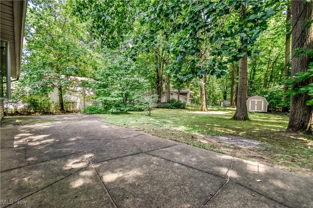 View of yard with a storage shed and a patio area