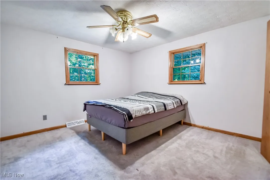 Bedroom featuring light carpet and a ceiling fan