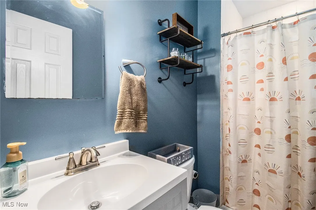Full bath featuring vanity and curtained shower
