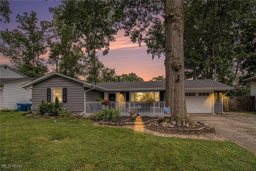 Ranch-style house with a porch, driveway, and an attached garage