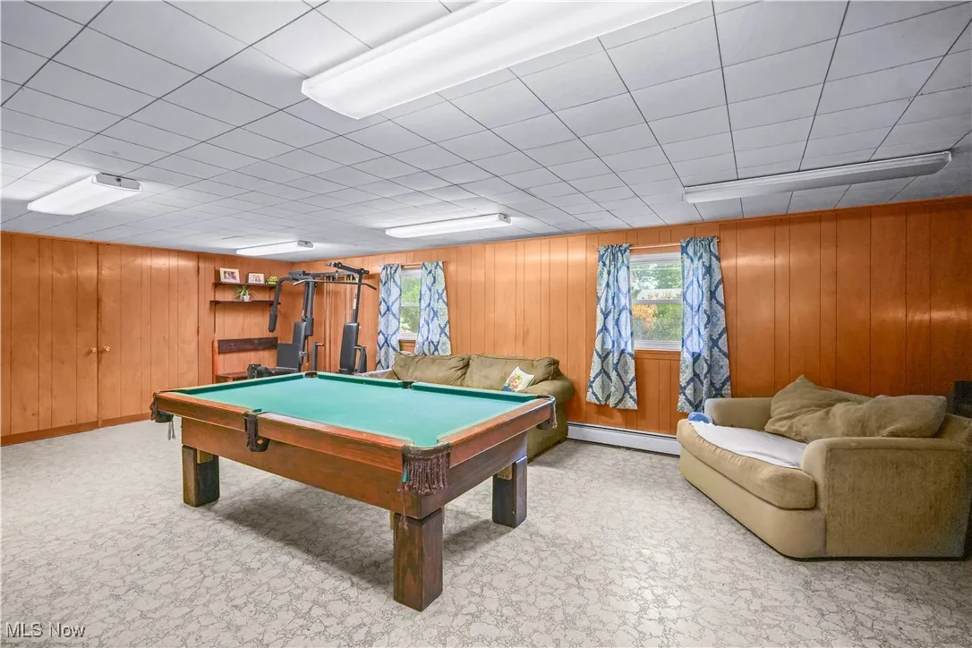 Game room featuring wooden walls, baseboard heating, and billiards