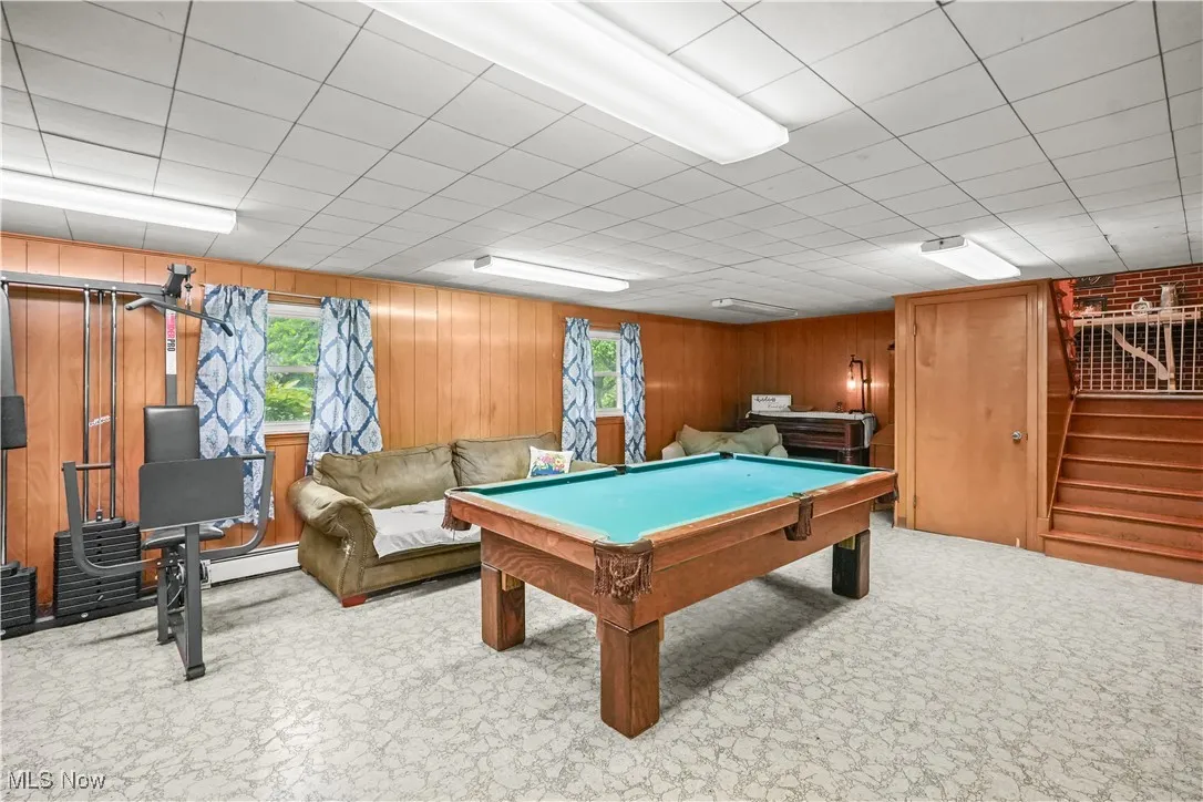 Rec room featuring wood walls, pool table, and a baseboard radiator