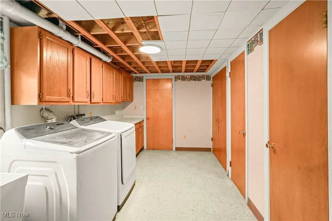 Laundry area featuring cabinet space, separate washer and dryer, and light flooring