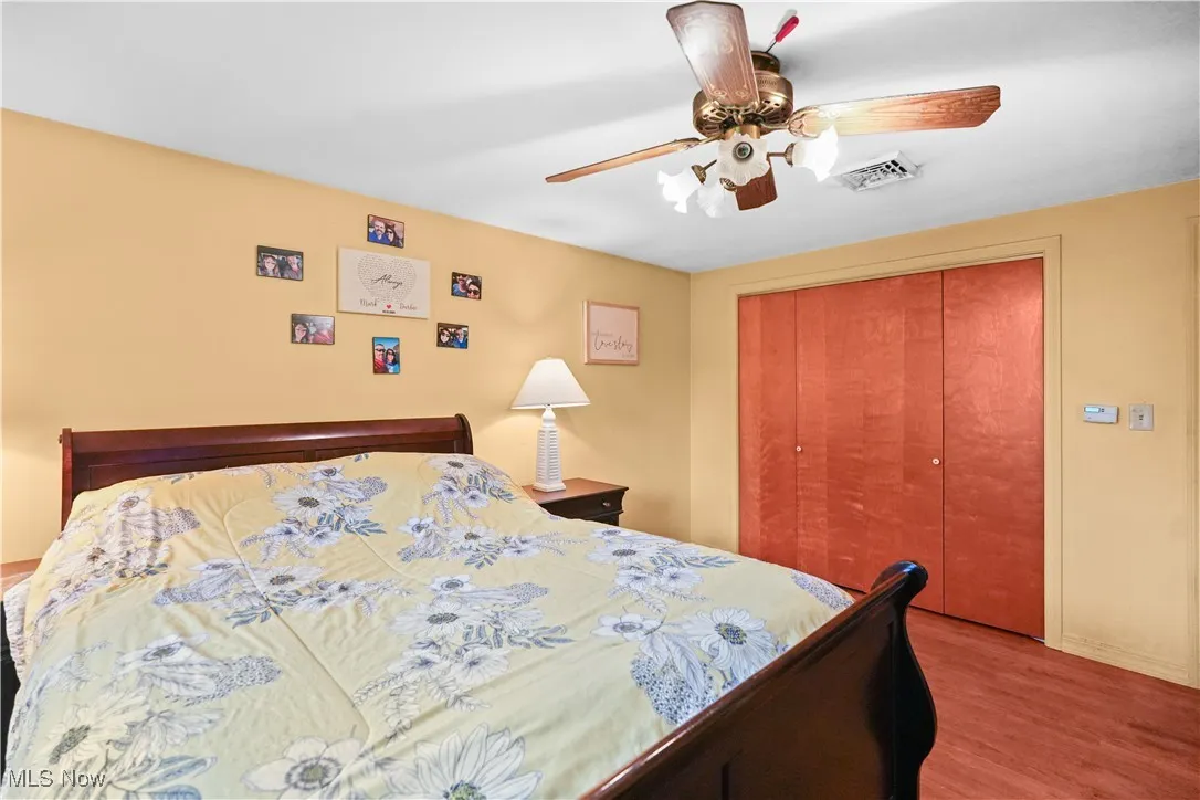 Bedroom with wood finished floors, a closet, and ceiling fan