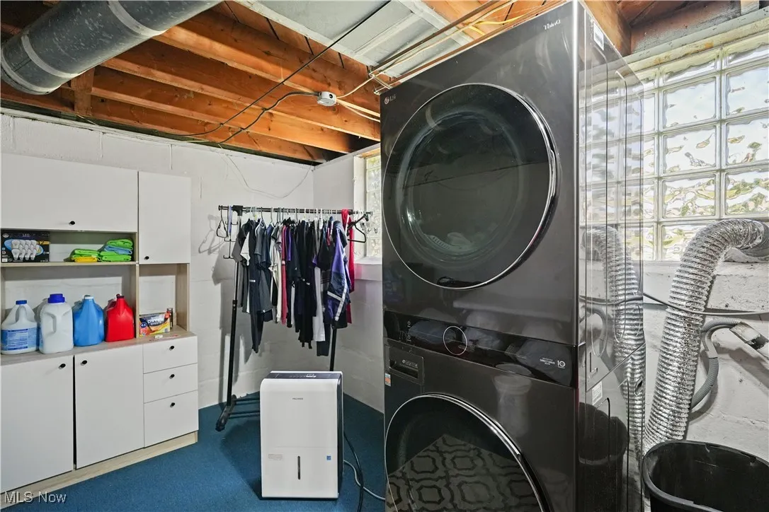 Laundry area with stacked washer / dryer and cabinet space